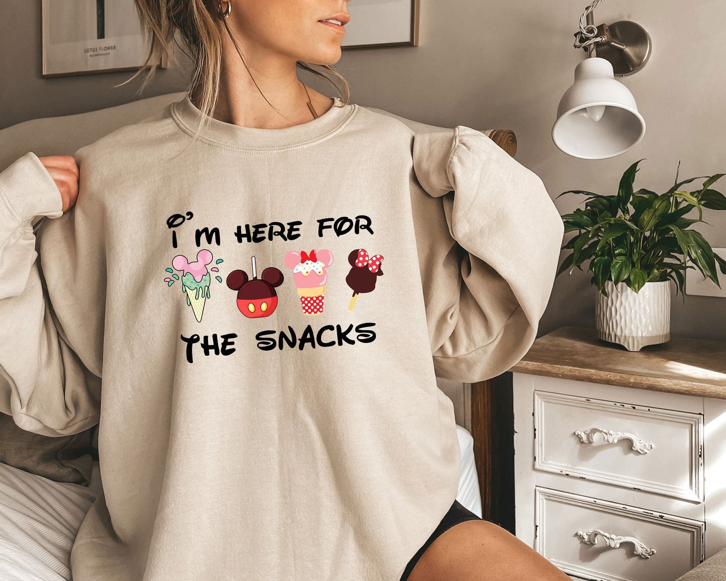 a woman wearing a sweatshirt that says i'm here for the snacks