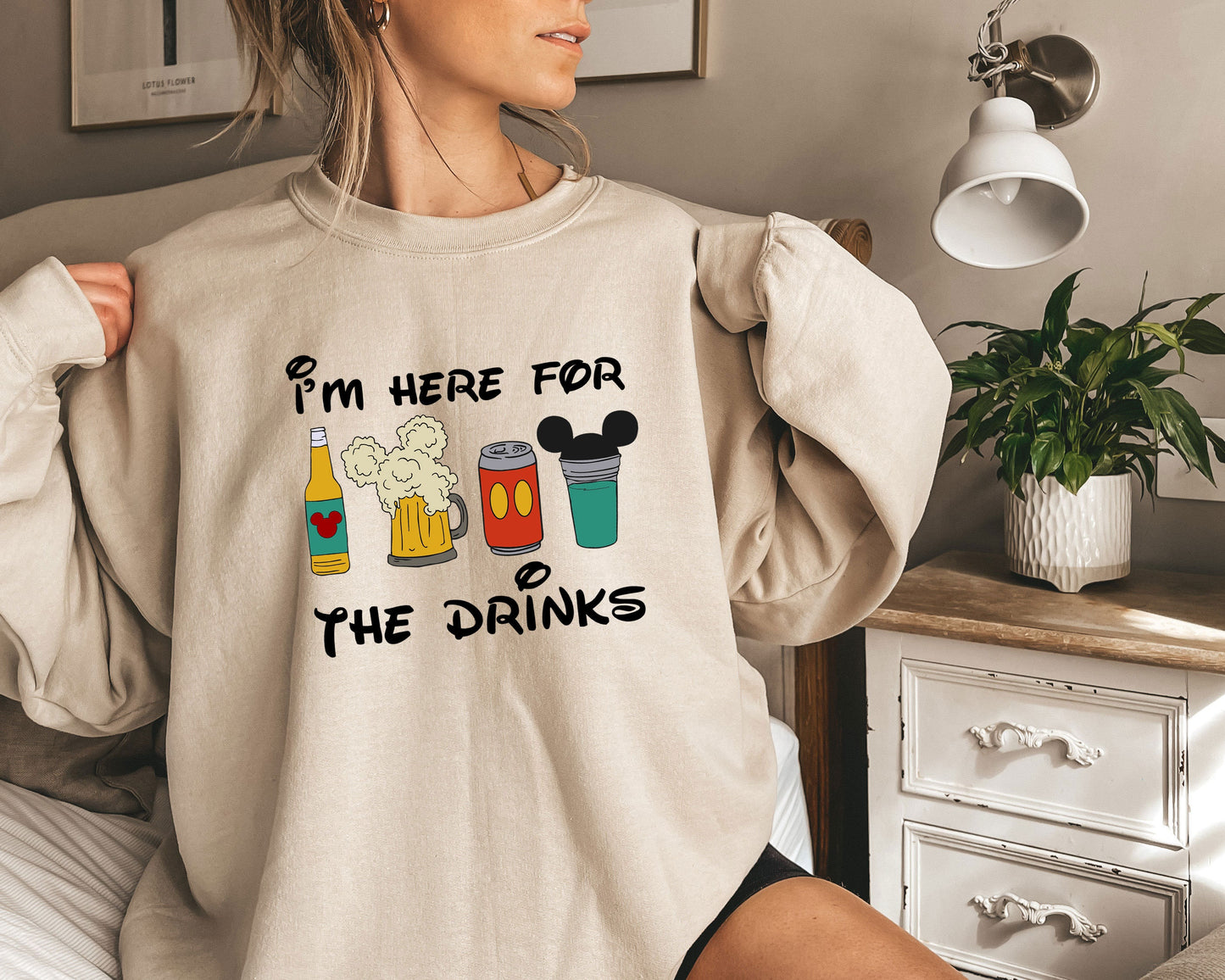 a woman wearing a sweatshirt that says i'm here for the drinks
