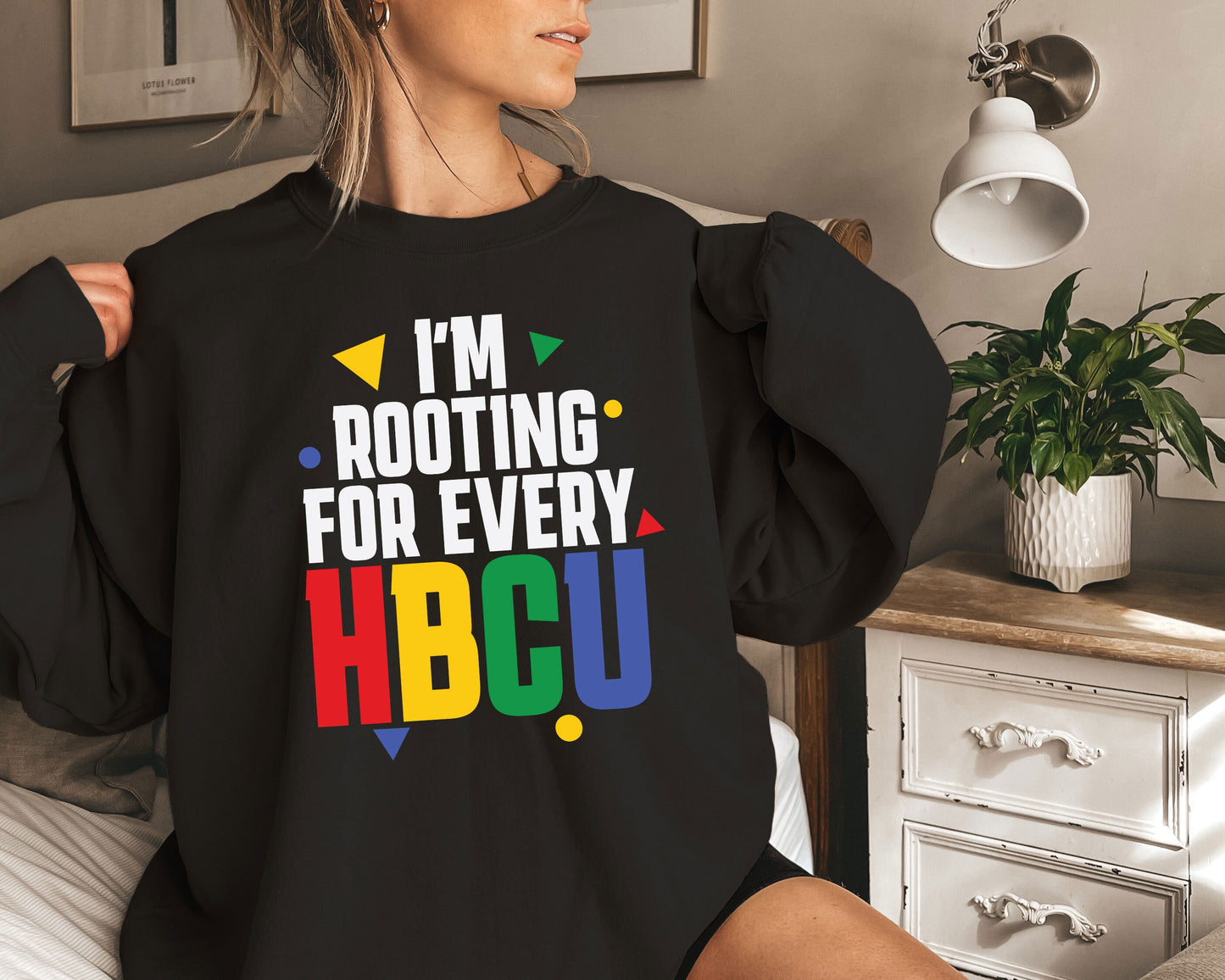 a woman sitting on a bed wearing a black shirt that says i'm root