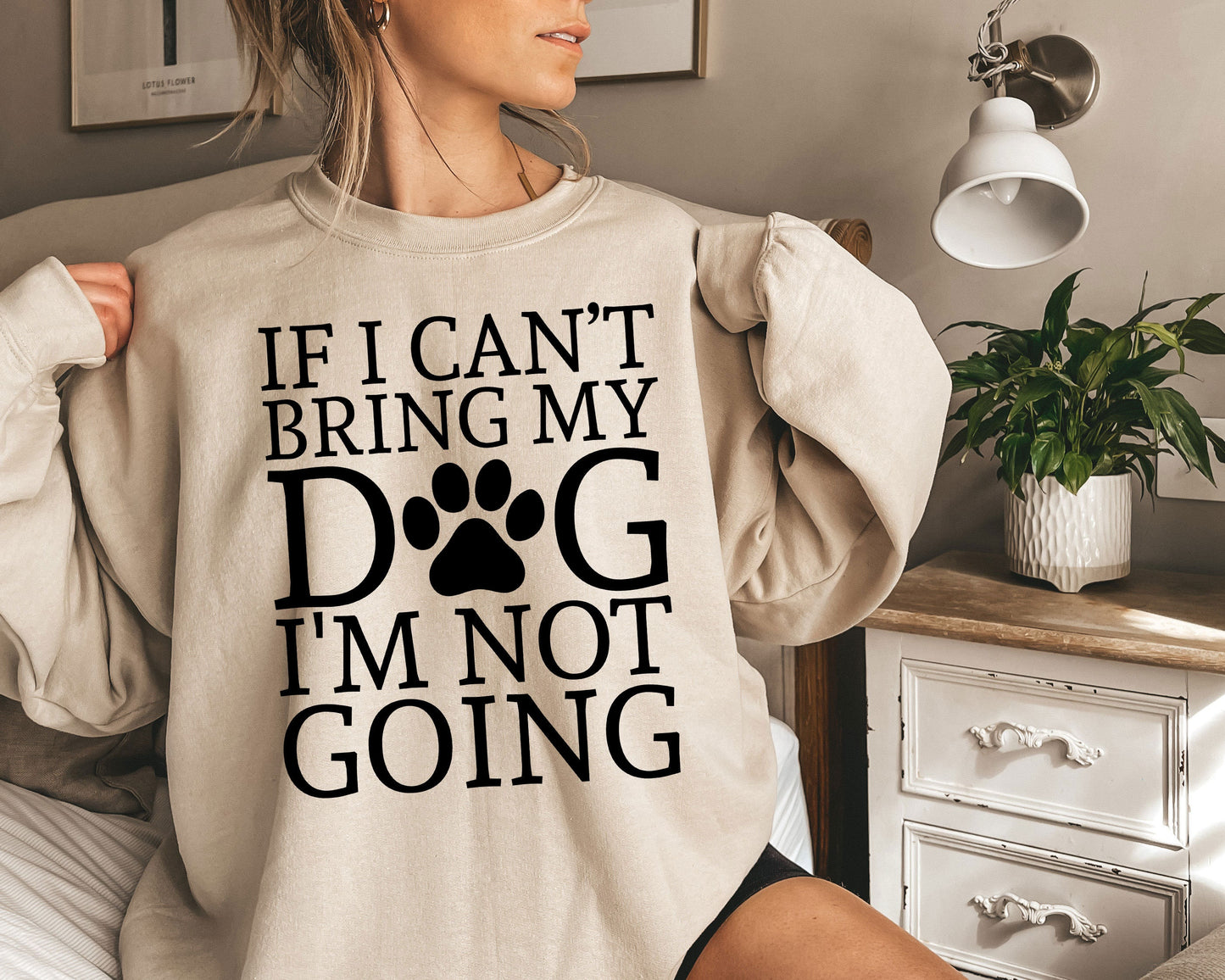 a woman wearing a sweatshirt that says if i can't bring my dog i