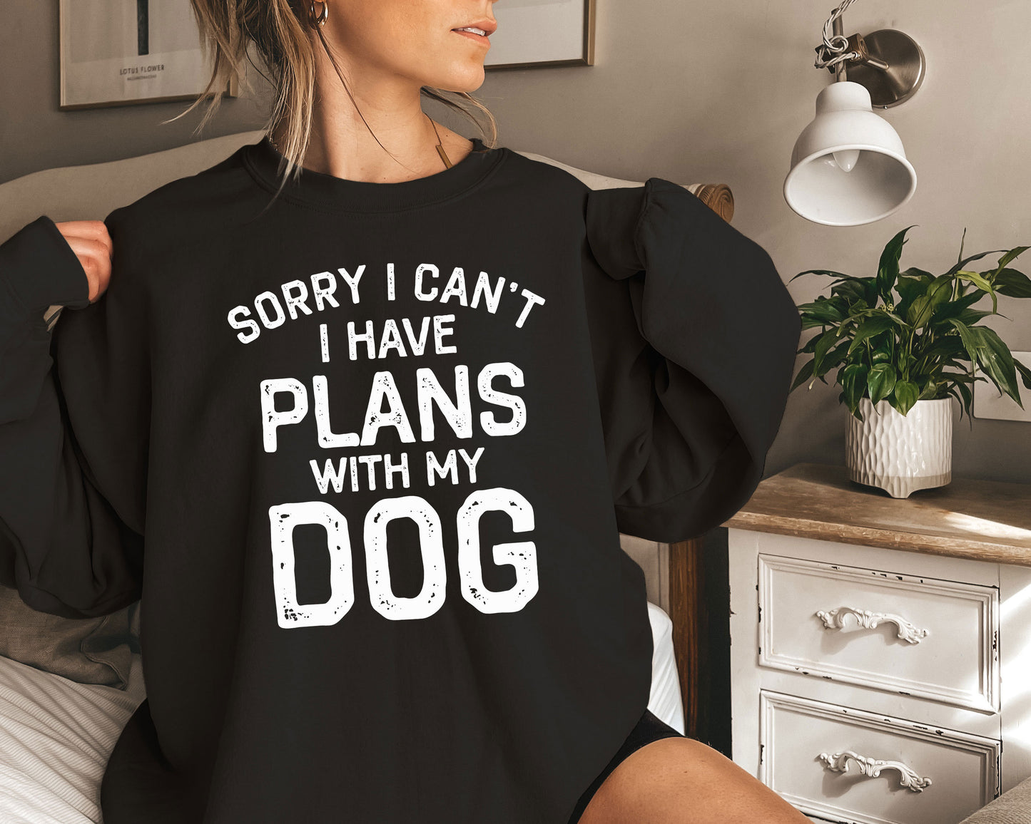 a woman sitting on a bed with a black shirt that says sorry i can '