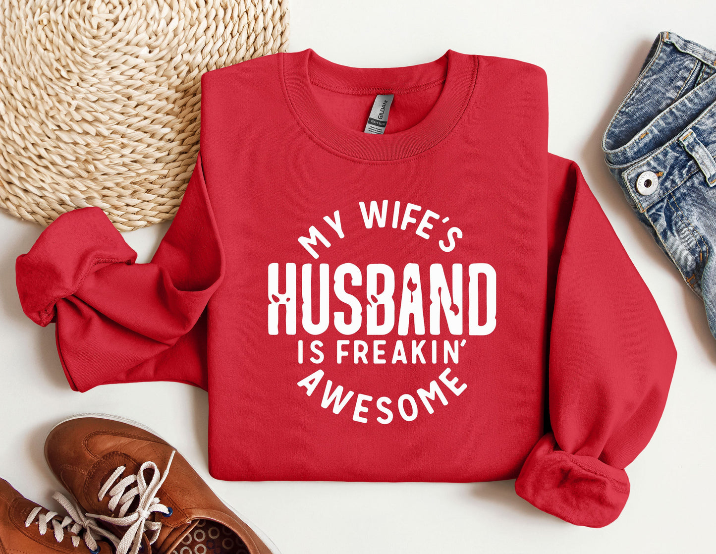 a red sweatshirt that says, my wife's husband is freakin'awesome