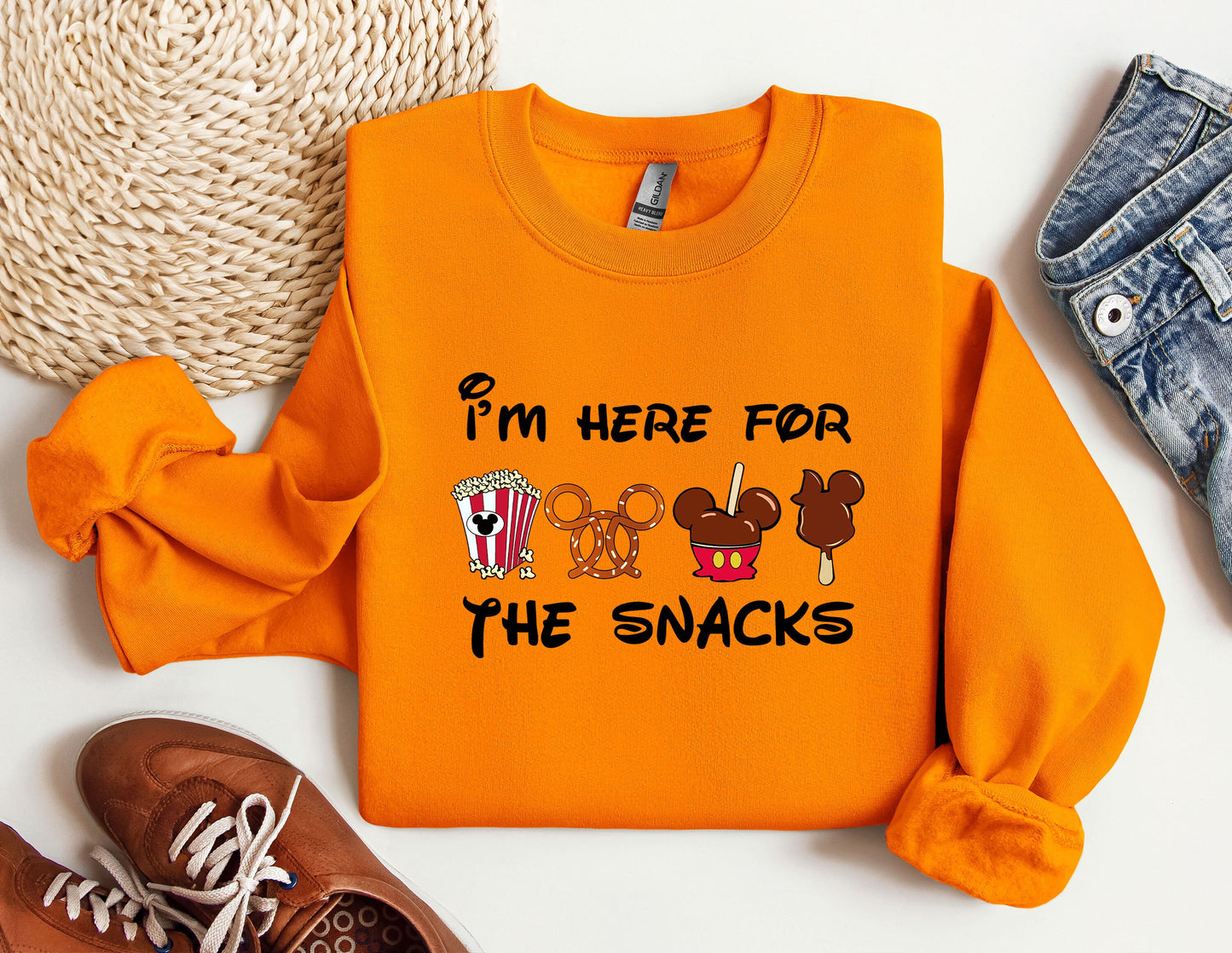 a pair of sneakers and an orange sweatshirt with i'm here for the snacks