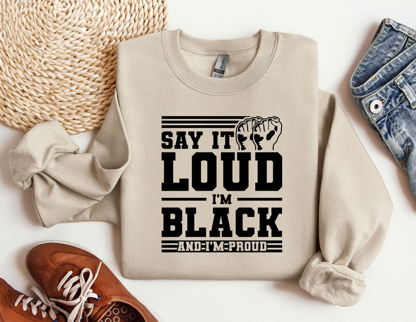 a sweater that says, say it's loud in black and a pair of