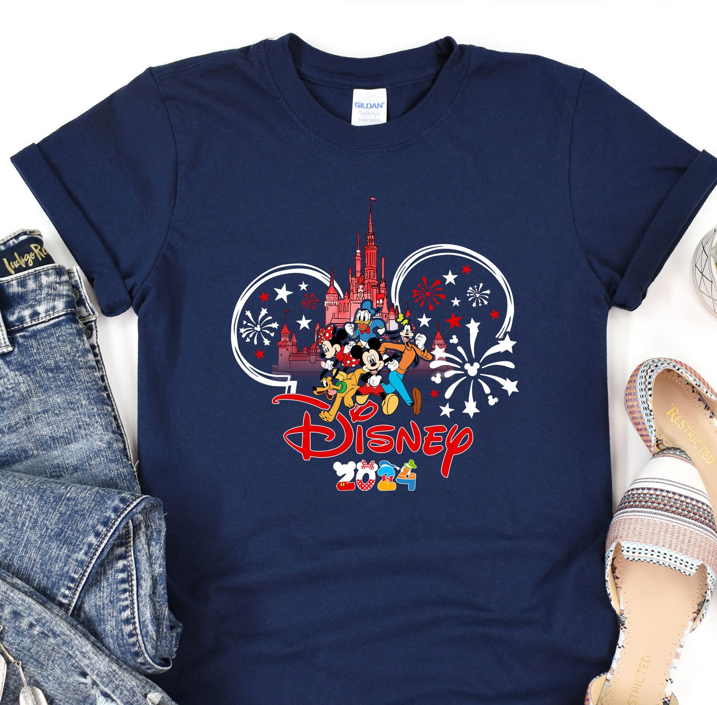 a mickey mouse shirt with fireworks and a castle in the background
