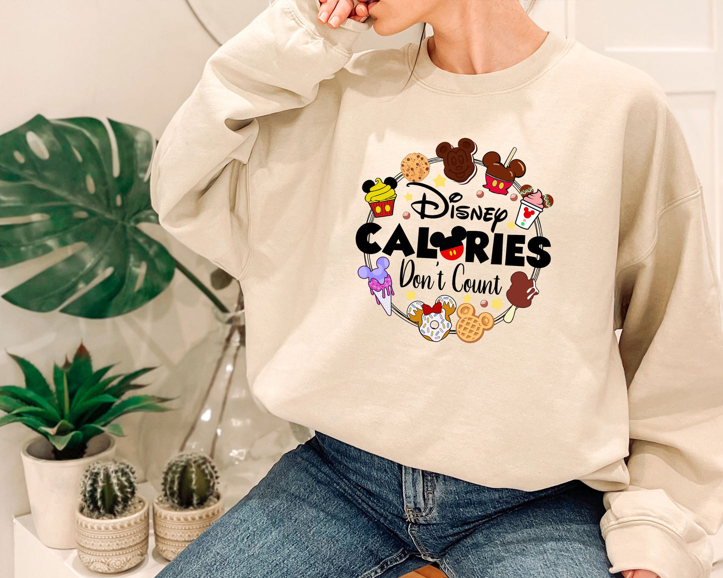 a woman sitting on a chair wearing a sweatshirt that says disney calories don '