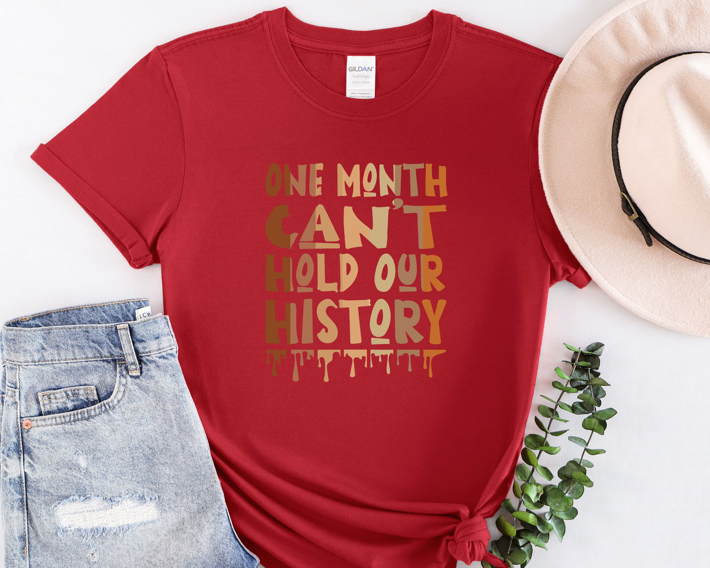 a red t - shirt with the words we month can't hold our history