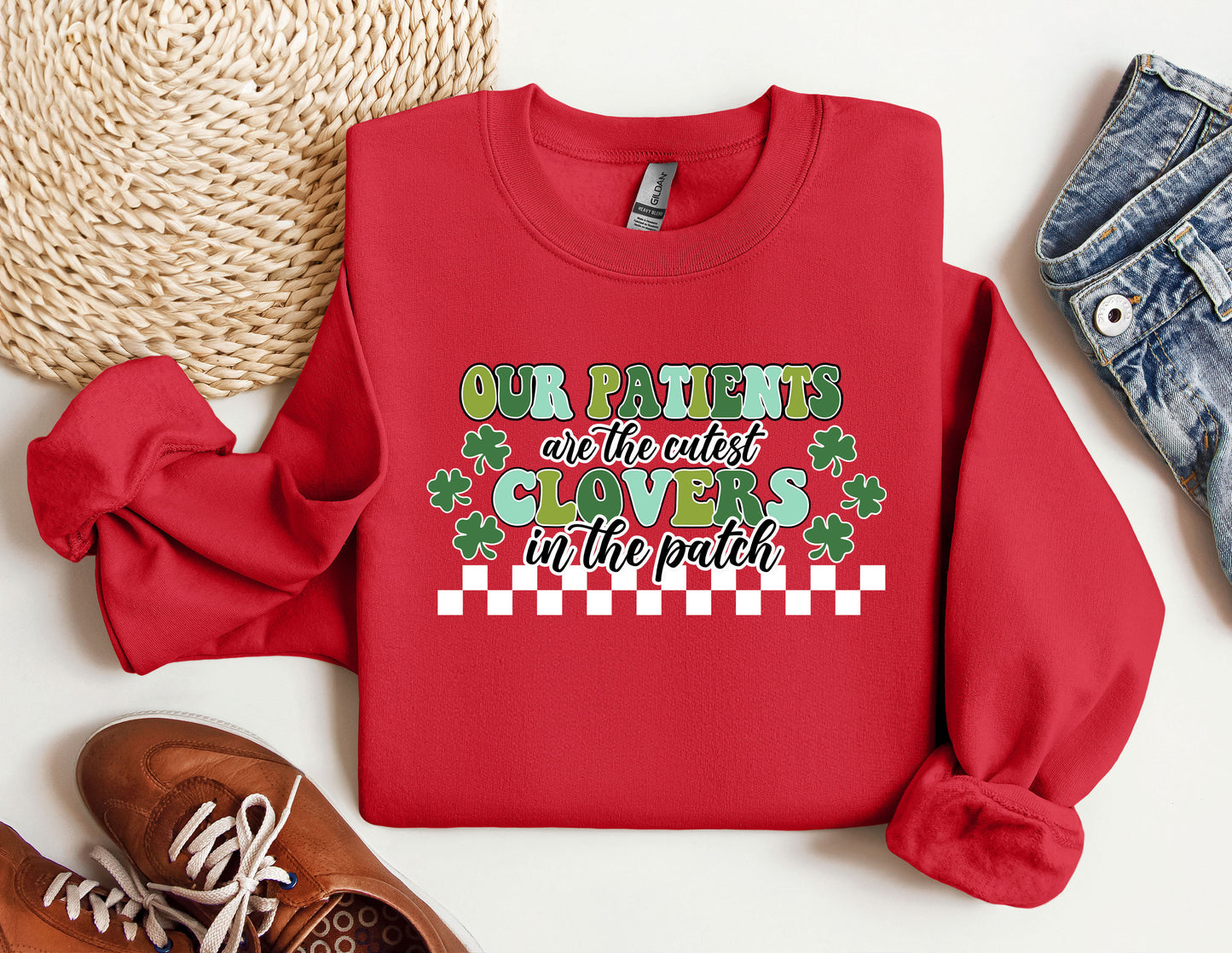 a red sweater with a message on it next to a pair of shoes
