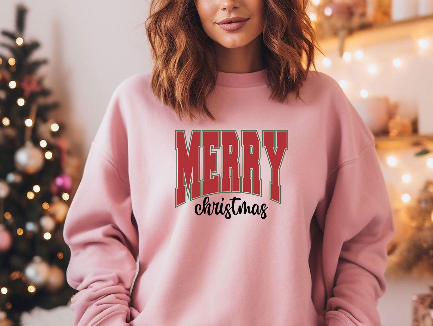 a woman wearing a pink merry christmas sweatshirt