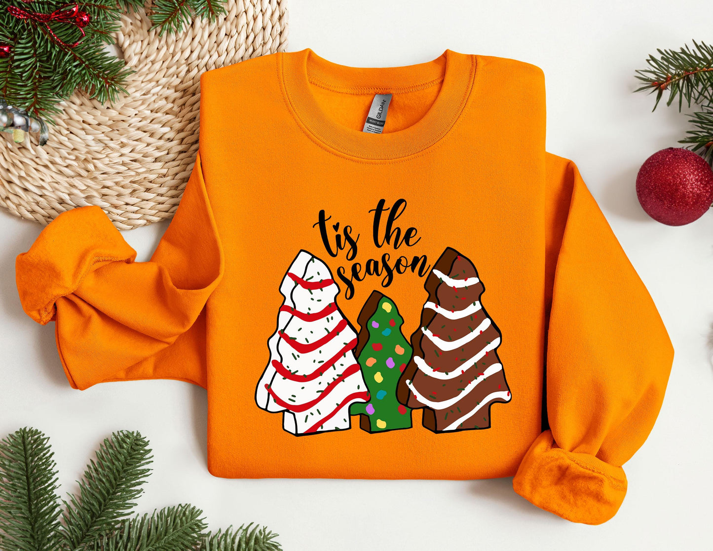 an orange shirt with a christmas tree and two trees on it