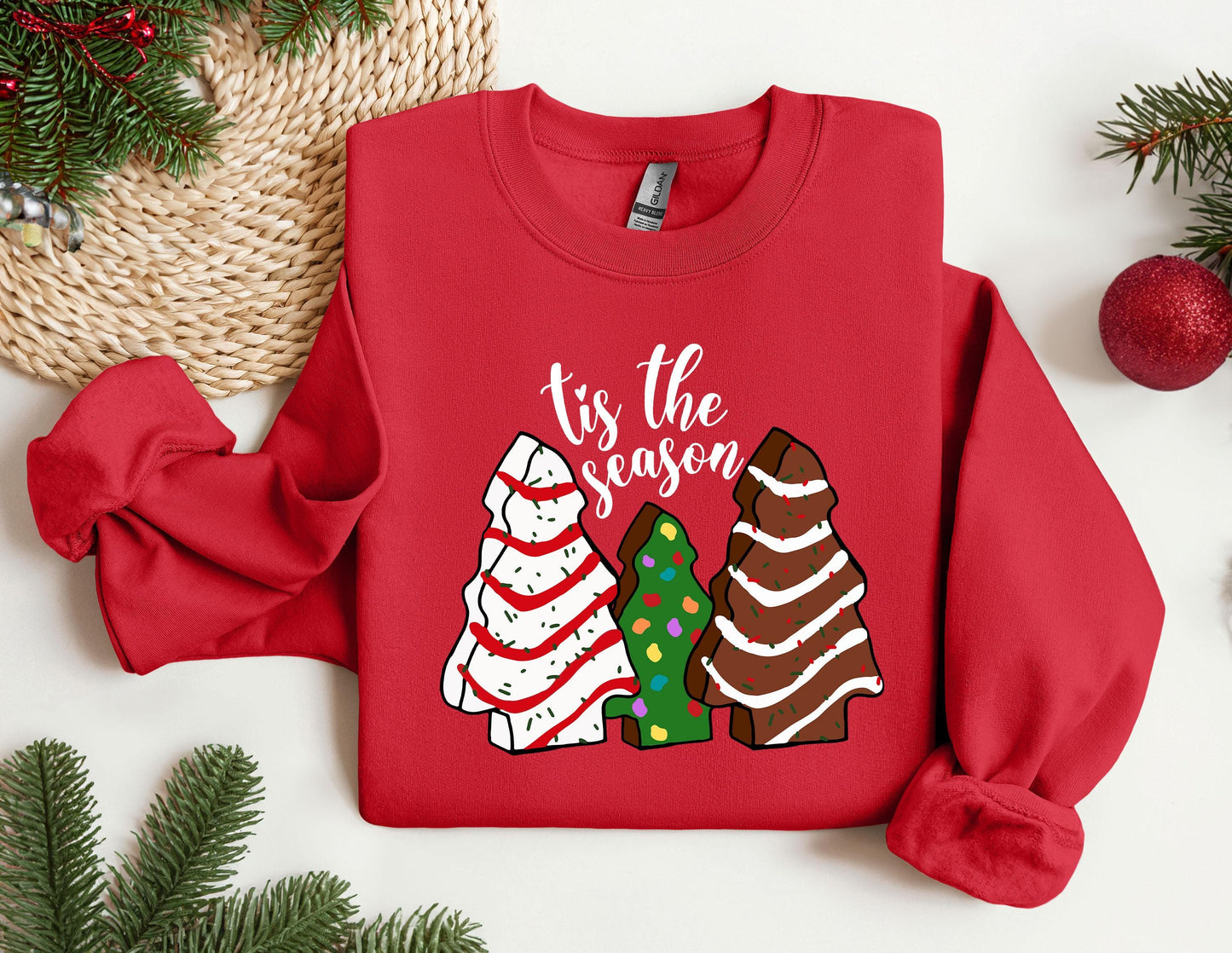 a red sweater with a christmas tree and three trees on it