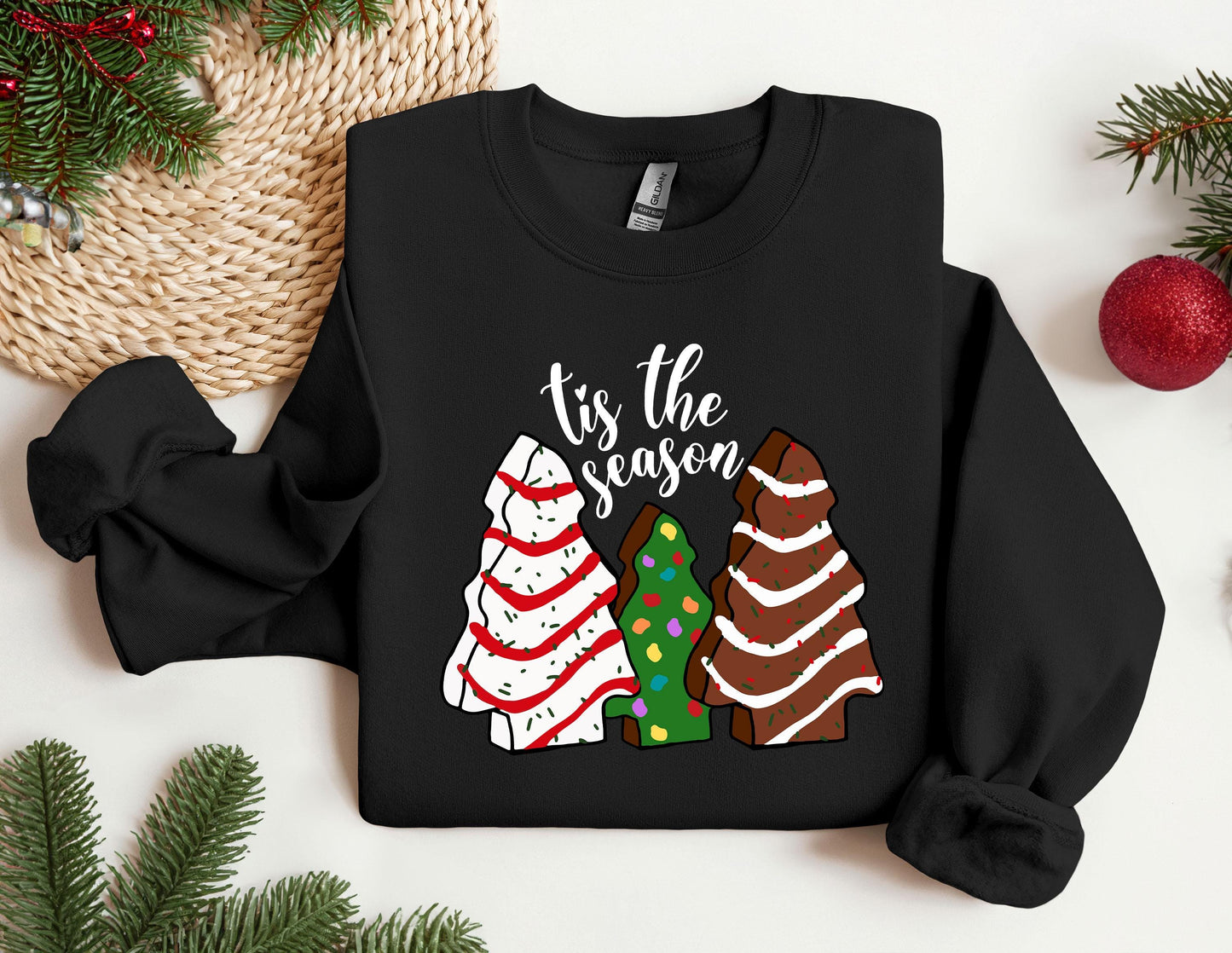 a black shirt with a christmas tree and three sweaters on it