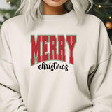 a woman wearing a merry christmas sweatshirt in front of a christmas tree