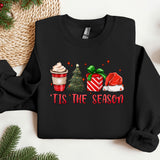 a black shirt with a christmas sweater and a cup of coffee