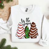 a white sweater with a christmas tree and two sweaters on it