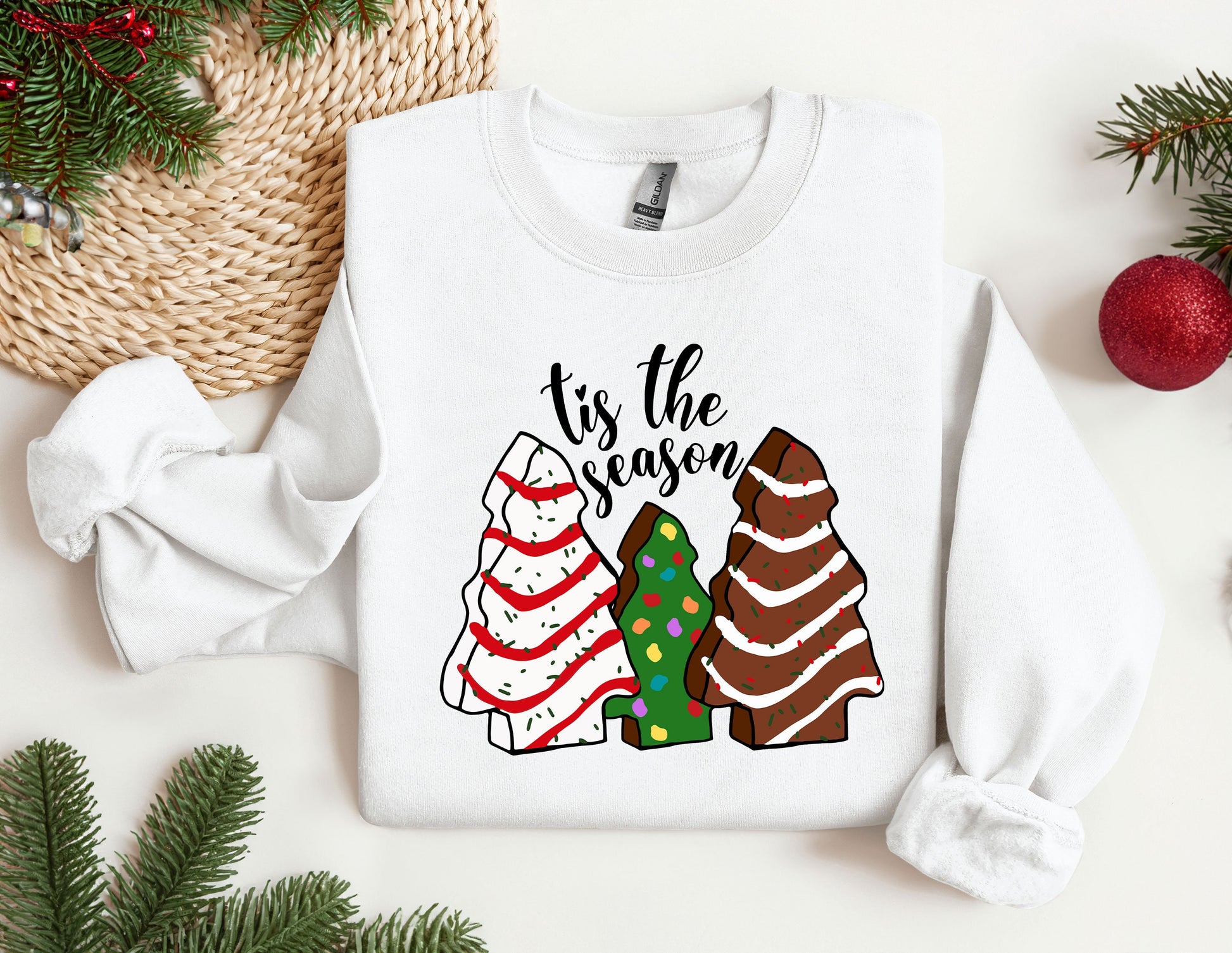 a white sweater with a christmas tree and two sweaters on it