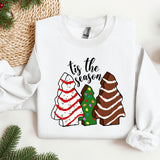 a white sweater with a christmas tree and two sweaters on it