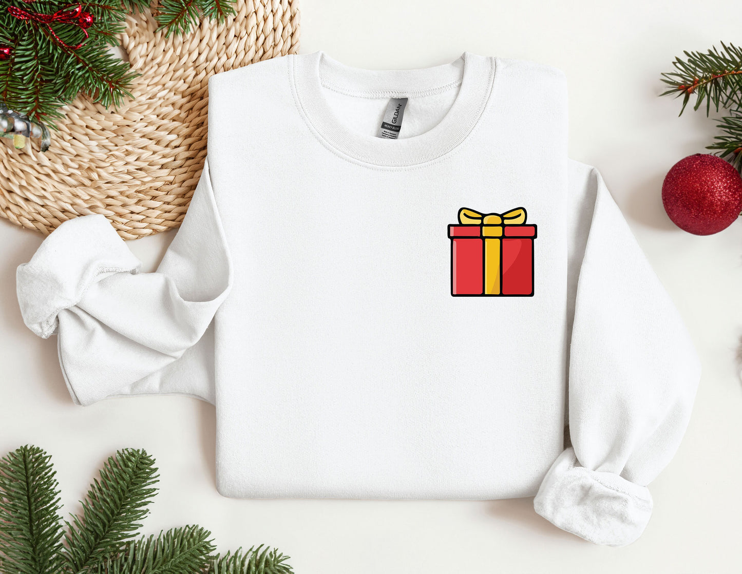 a white sweater with a red and yellow gift box on it