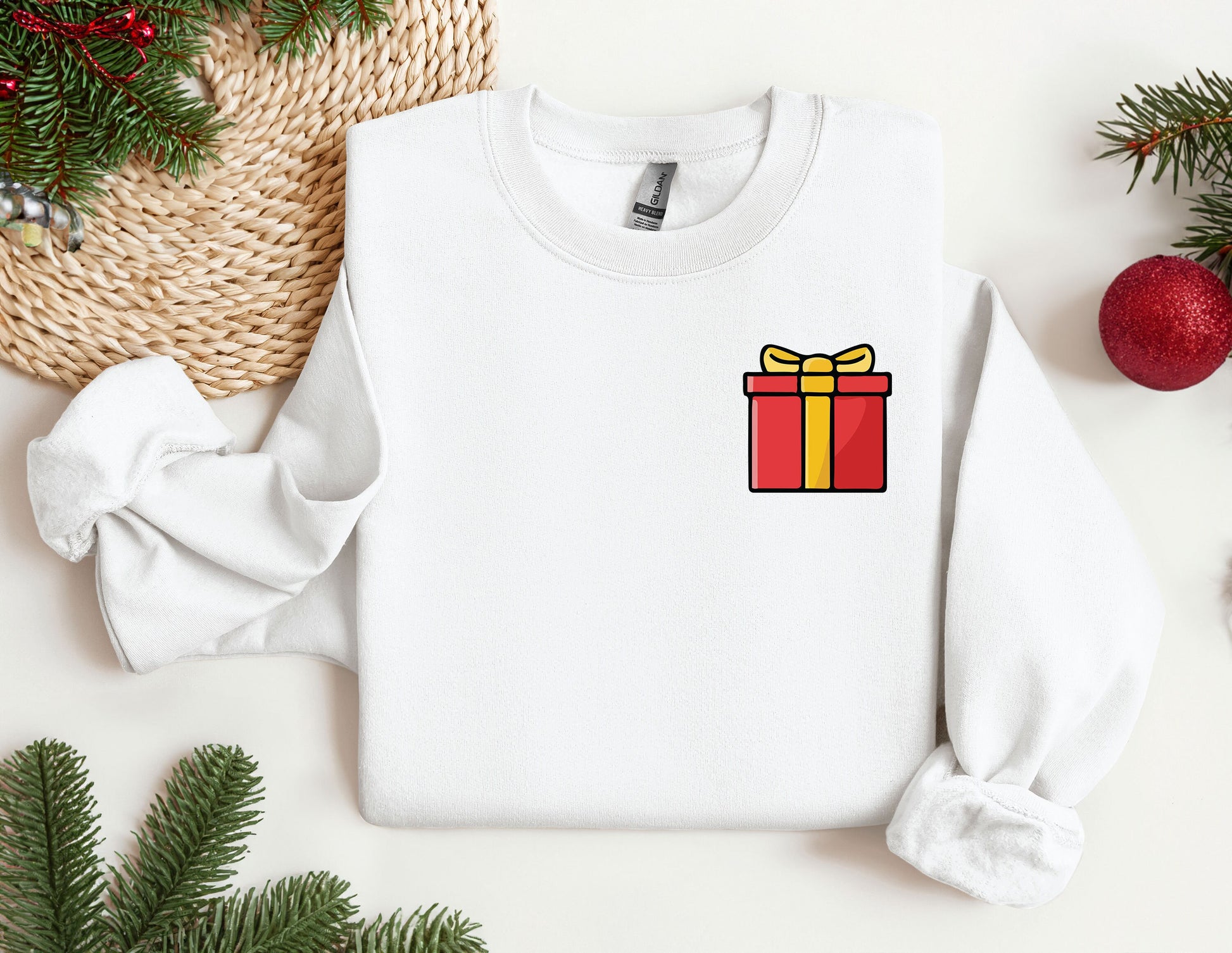 a white sweater with a red and yellow gift box on it