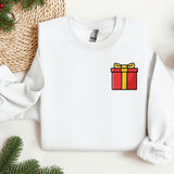 a white sweater with a red and yellow gift box on it