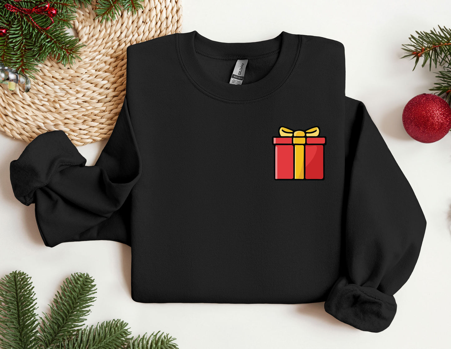 a black sweater with a red and yellow gift box on it