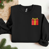 a black sweater with a red and yellow gift box on it