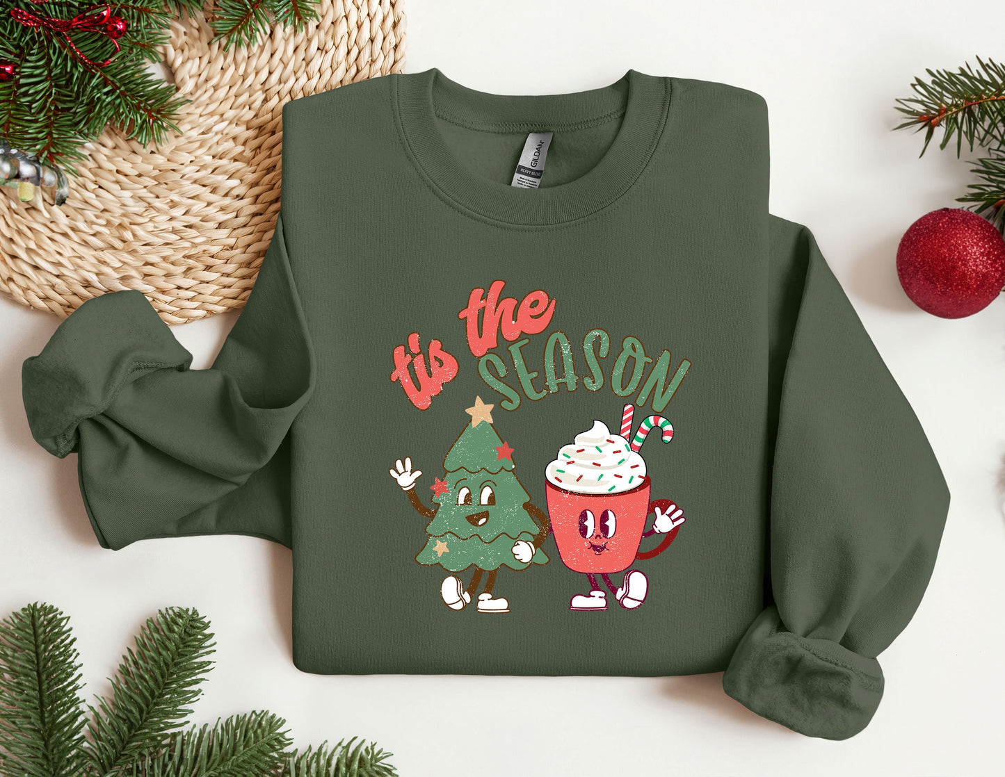 a green sweatshirt with a christmas tree and a cupcake on it