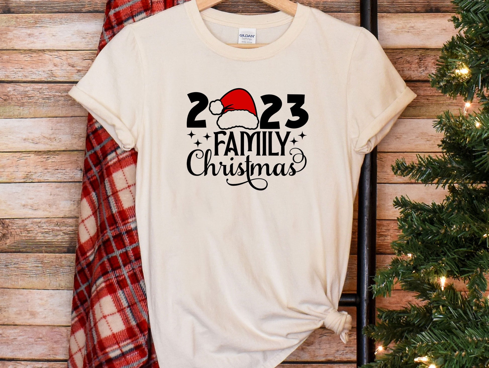 a t - shirt with a santa hat on it next to a christmas tree