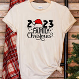 a t - shirt with a santa hat on it next to a christmas tree