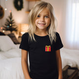 a little girl that is standing in front of a bed