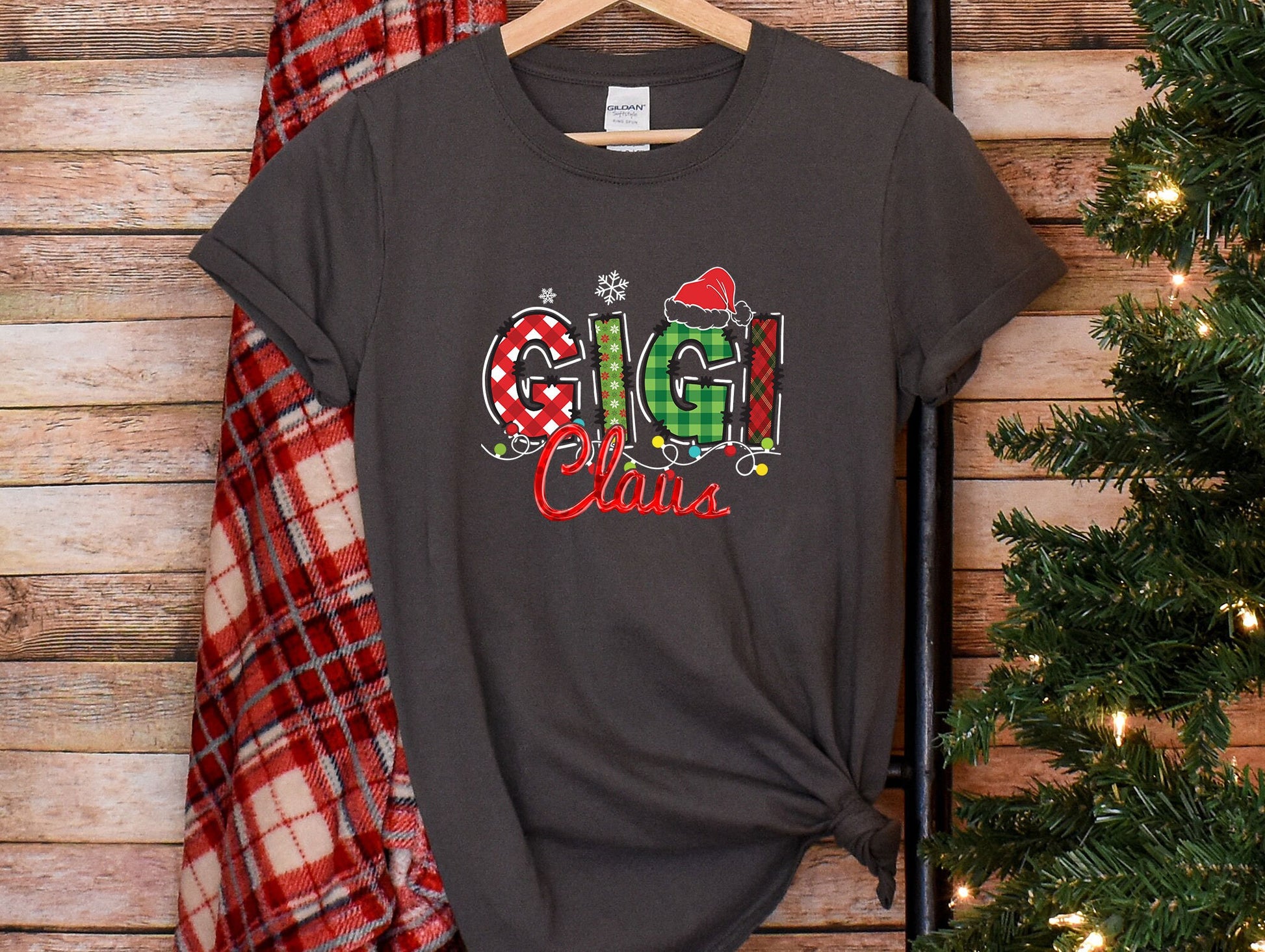 a t - shirt with the word christmas on it next to a christmas tree