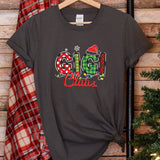 a t - shirt with the word christmas on it next to a christmas tree