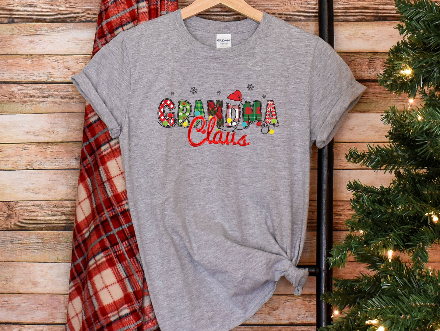 a t - shirt with the word santa claus on it next to a christmas tree