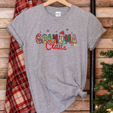 a t - shirt with the word santa claus on it next to a christmas tree