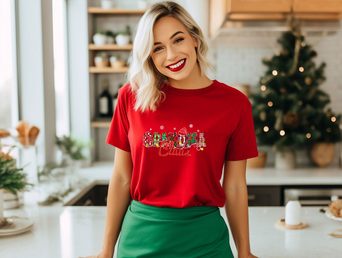 a woman standing in a kitchen wearing a red shirt and green skirt