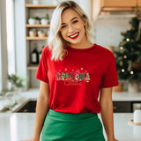 a woman standing in a kitchen wearing a red shirt and green skirt