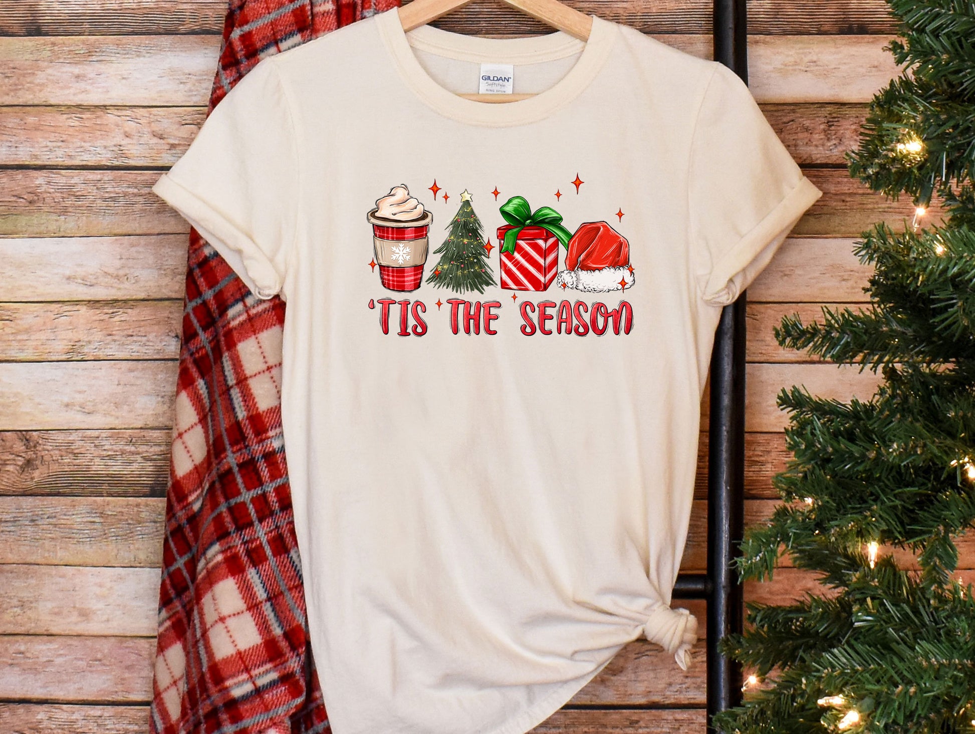 a t - shirt that says tis the season next to a christmas tree