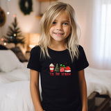 a little girl that is standing in front of a bed