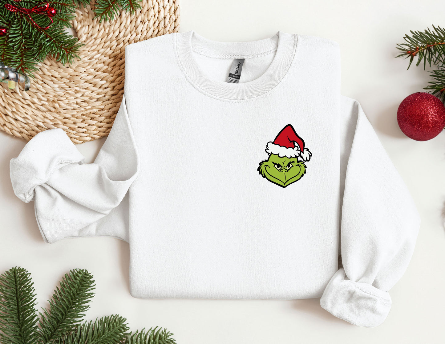 a white sweater with a green face wearing a santa hat