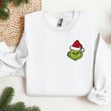a white sweater with a green face wearing a santa hat
