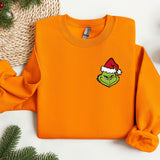 an orange sweatshirt with a green grin face on it