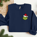 a blue sweatshirt with a green grin face wearing a santa hat