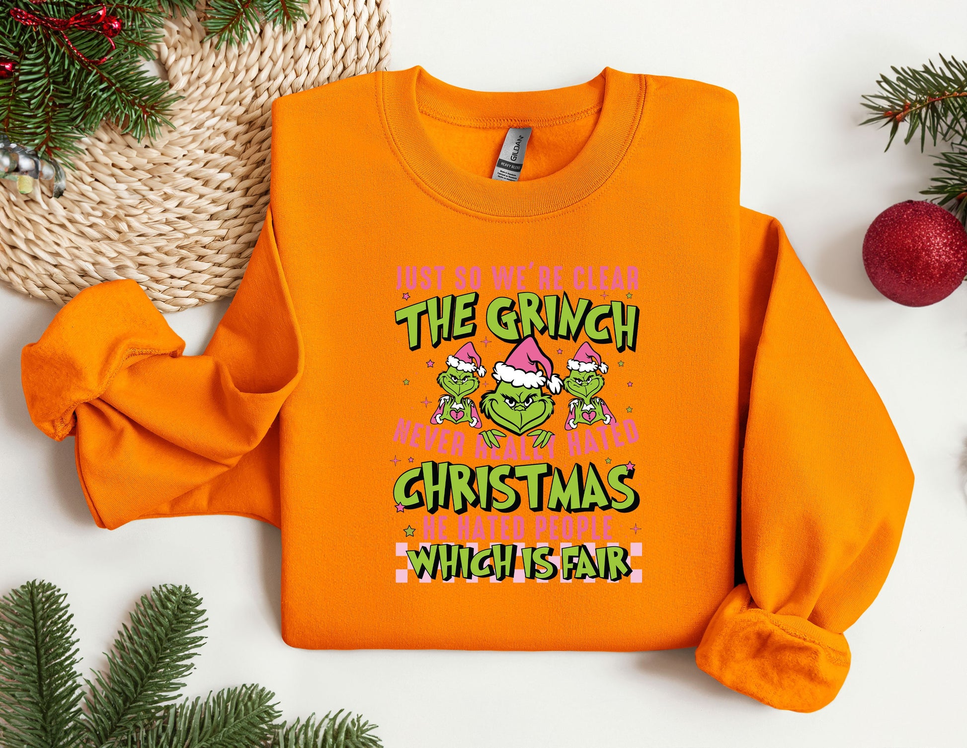 an orange sweatshirt with the grin on it