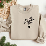 a sweater with a message on it next to christmas decorations