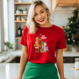 a woman standing in a kitchen wearing a red shirt and green skirt