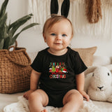a baby sitting on a bed wearing a black shirt
