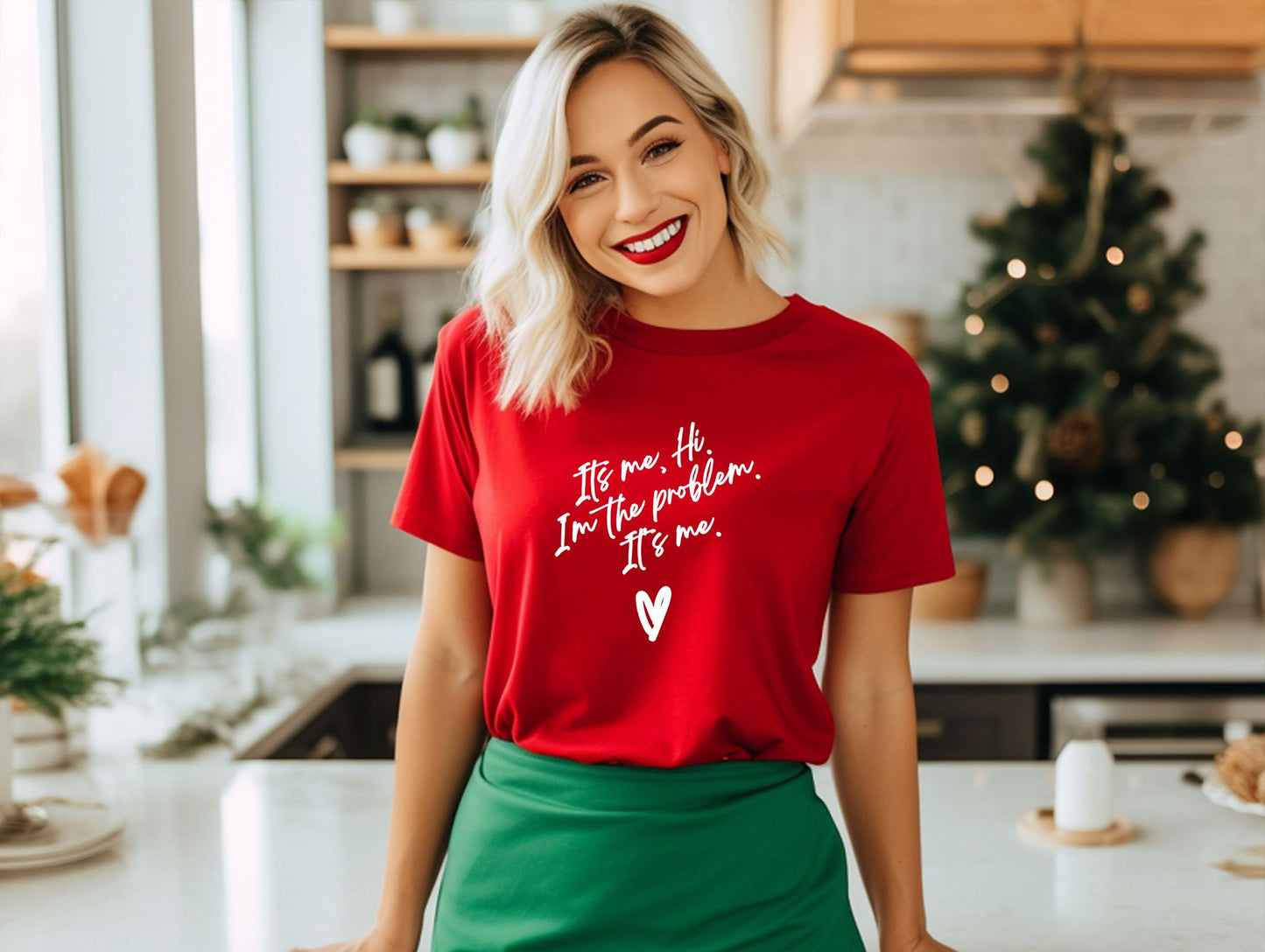 a woman standing in a kitchen wearing a red shirt