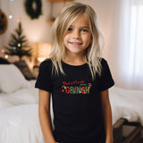a little girl that is standing in front of a bed