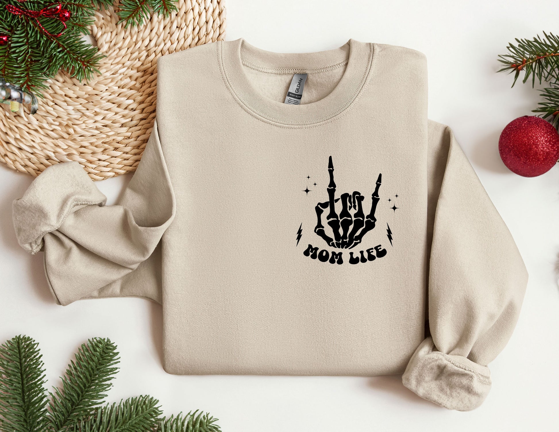 a sweater with a hand drawn on it next to a christmas tree