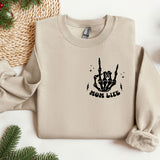 a sweater with a hand drawn on it next to a christmas tree